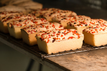 Cube cakes with fruit sprinkle garnish put on the grid