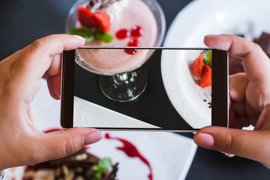 Food photos of delicious desserts by smartphone in restaurant. Creamy strawberry souffle, photoshoot and new technology, close up pov picture