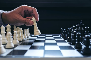 Close up of hands confident businessman colleagues playing chess game to development analysis new strategy plan, leader and teamwork concept for success.