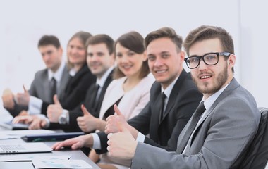 business team with thumbs up while sitting at his Desk