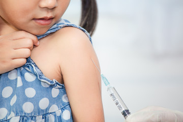 Doctor injecting vaccination in arm of asian little child girl,healthy and medical concept