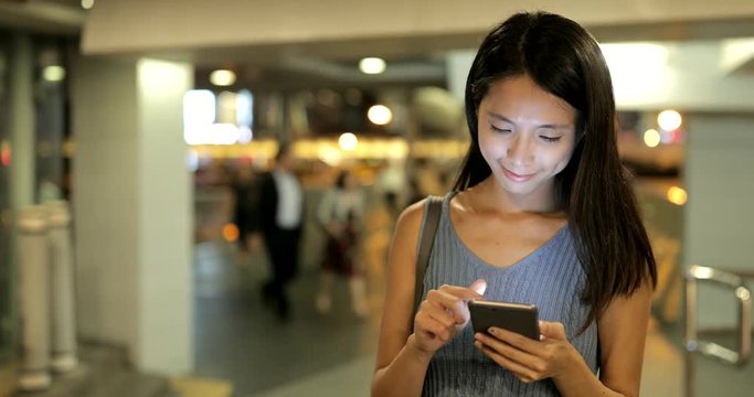 Woman looking at mobile phone in the city of Hong Kong