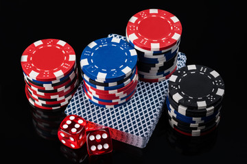 beautiful dice set, cards and poker chips on a black background