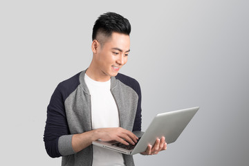 Confident young asian businessman holding laptop