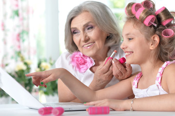 Obraz na płótnie Canvas little girl with granny using laptop