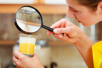 Woman inspecting food with magnifying glass.