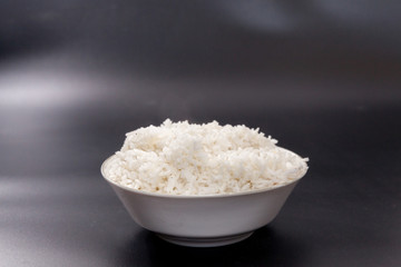 cooked rice on bowl on black background