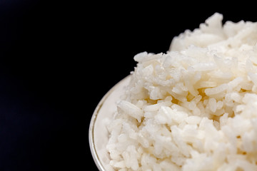 cooked rice on bowl on black background