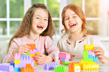 little girls playing with plastic blocks
