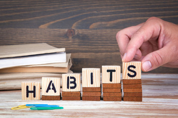 Habits concept. Wooden letters on the office desk, informative and communication background.