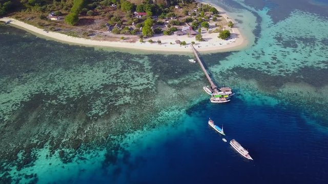 Beautiful aerial view footage of Kanawa Island Resort with jetty, boats, and turquoise water at East Nusa Tenggara, Indonesia. Shot in 4k resolution