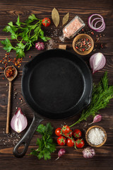 herbs and spices around cast iron skillet