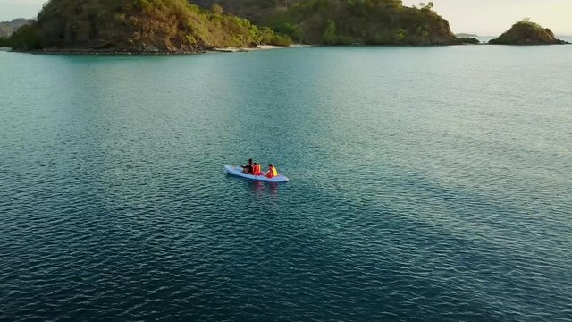Beautiful aerial view footage of people kayaking from a drone flying spinning on the sea in Labuan Bajo, East Nusa Tenggara, Indonesia. Shot in 4k resolution