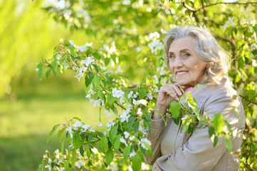 senior woman near blooming tree