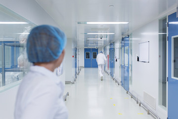 Bright, white with blue doors, a sterile corridor in a medical facility.