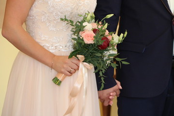 bride holding in her hand a beautiful bright bouquet with delicate ribbons