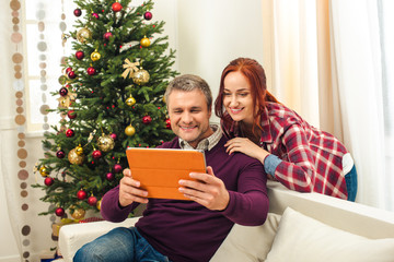 couple with digital tablet at christmastime
