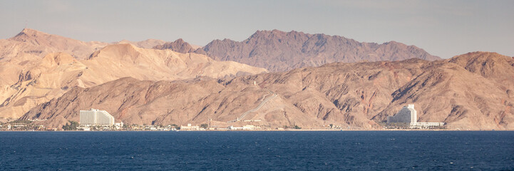 Coastline landscape of the boarder between Egypt and Israel on the Red Sea in the Gulf of Aqaba. The fence is the boarderline. / Egypt and Israel Coastal Landscape