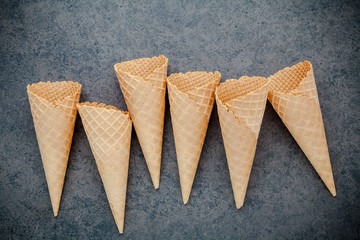 Flat lay ice cream cones collection on dark stone background . Blank crispy ice cream cone with copy space for sweets menu design.