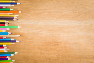 Obraz premium Color pencils on the wooden table. Art concept. Top view. Empty place for a text or drawing on the background.