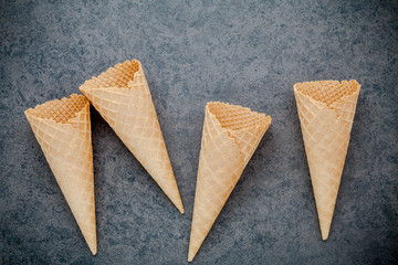 Flat lay ice cream cones collection on dark stone background . Blank crispy ice cream cone with copy space for sweets menu design.