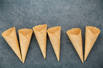 Flat lay ice cream cones collection on dark stone background . Blank crispy ice cream cone with copy space for sweets menu design.