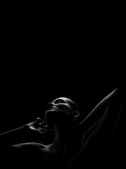 aroused woman posing sensually holding head up on black background with copy space, monochrome