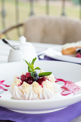 Pavlova cake with figs, blueberries, raspberries and mint leaves