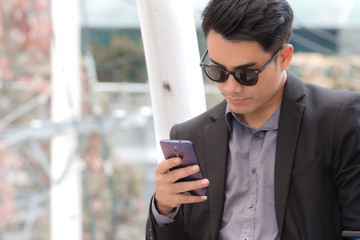 Smart young business man is checking message in his mobile phone