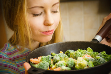 Woman cooking stir fry frozen vegetable on pan