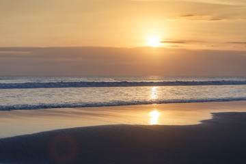 Fototapeta na wymiar Golden sunset on the tropical beach. Cuta beach on Bali island. Indonesia