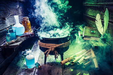 Magical cauldron with scrolls, books and potions for Halloween