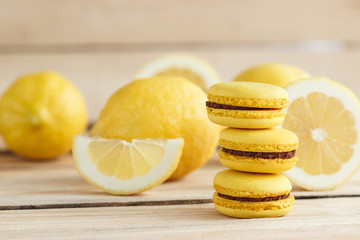 Yellow french macarons with lemons on the wooden board