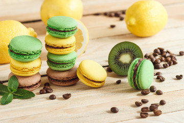 Green and yellow french macarons with kiwi, lemon and mint decorations