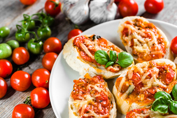 Traditional italian food, antipasti or bruschetta baked with tomatoes, basil and cheese