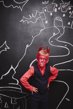 Kid in devil costume making a face