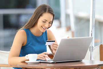 Fototapeta premium Happy buyer buying on line in a bar