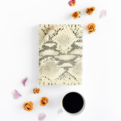 Feminine notepad with cup of coffee and dry roses