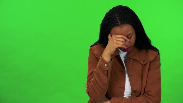 A young black woman has depression and think about something - green screen
