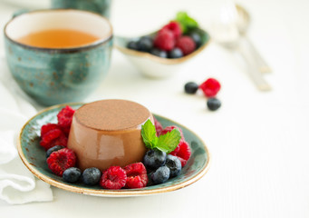 Delicious home-made chocolate dessert Panna cotta. Cream-caramel, caramel custard, with raspberries and blueberries.