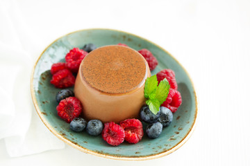 Delicious home-made chocolate dessert Panna cotta. Cream-caramel, caramel custard, with raspberries and blueberries.