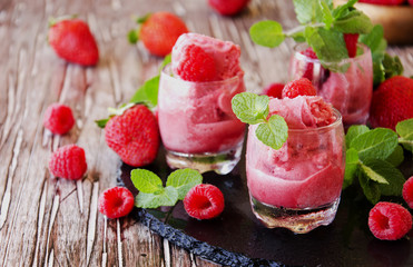 frozen yogurt, sorbet with strawberries, raspberries and mint, selective focus