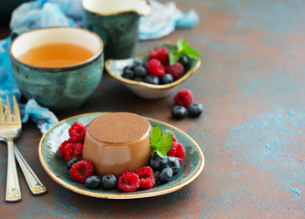 Delicious home-made chocolate dessert Panna cotta. Cream-caramel, caramel custard, with raspberries and blueberries.