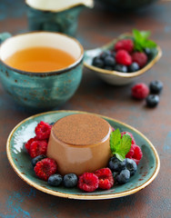 Delicious home-made chocolate dessert Panna cotta. Cream-caramel, caramel custard, with raspberries and blueberries.