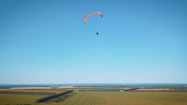 Paraplane, paraglider in the air aerial shot. Extreme life. A man is flying on a paraglider