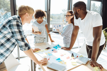 Cheerful young colleagues working on their business project