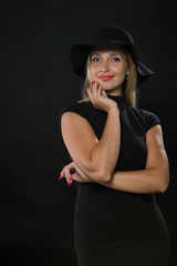 Young cheerful woman portrait of a confident businesswoman showing by hands on a black background. Ideal for banners, registration forms, presentation, landings, presenting concept