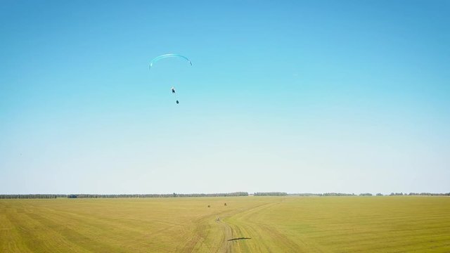 Paraplane, paraglider in the air aerial shot. Extreme life. A man is flying on a paraglider