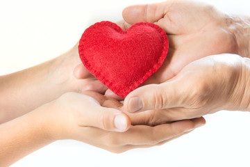 Obraz premium Red felt heart in childs and mens hands on white background. View from above. Copy space.