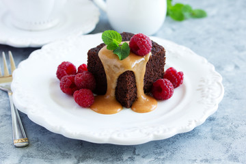 Sticky pudding with caramel sauce and fresh raspberries.